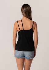 [Color: Black] A back facing image of a brunette model wearing a black stretchy bamboo knit tank top with asymmetric spaghetti straps, a scoop neckline, and a relaxed slim fit. 