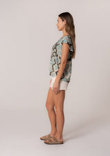 [Color: Black/Aqua] A side facing image of a brunette model wearing a classic short sleeve summer top in a green bohemian print. With short flutter sleeves and a v neckline. 