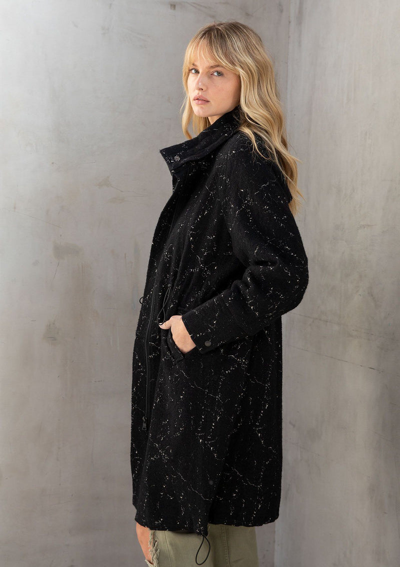 [Color: Black] A mid length trench coat with a paint splatter effect. Features a toggle cinch waist, essential side pockets, and a classic notched collar.