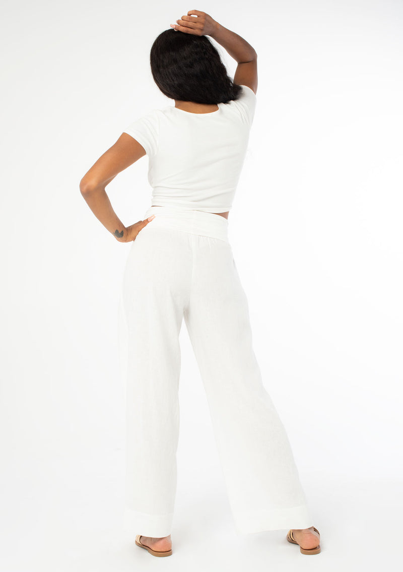 [Color: Cloud] A model wearing a cool white lounge pant in a cotton linen blend. With a long wide leg and a contrast knit fold over waistband.