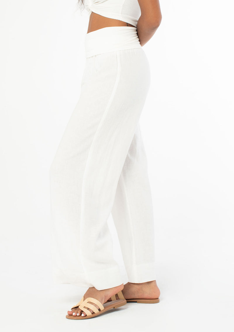 [Color: Cloud] A model wearing a cool white lounge pant in a cotton linen blend. With a long wide leg and a contrast knit fold over waistband.