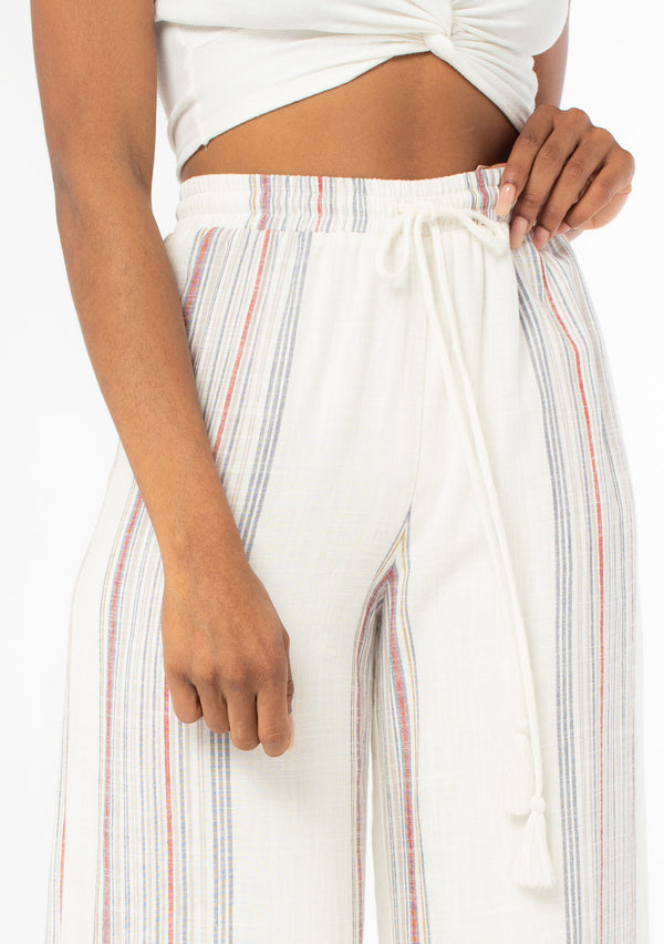 [Color: Ivory/Red] A close up front facing image of a black model wearing an off white and red striped wide leg drawstring pant. 