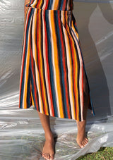 [Color: Black/Spice/Teal] A striped pleated midi skirt. Featuring a front slit. 