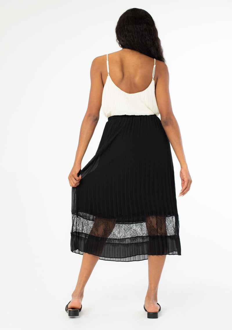 [Color: Black] A sunburst pleated mid length skirt. Featuring a delicate eyelash lace trim insert at the bottom of the skirt, an elastic waist, and elegant pleating throughout.