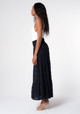 [Color: Black] A model wearing a bohemian black lace maxi skirt. 