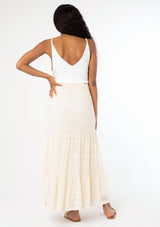 [Color: Natural] A back facing image of a black model wearing a bohemian off white lace maxi skirt.