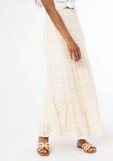 [Color: Natural] A close up image of a black model wearing a bohemian off white lace maxi skirt.