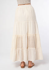 [Color: Natural] A woman wearing a bohemian off white cotton maxi skirt with embroidered detail throughout. 