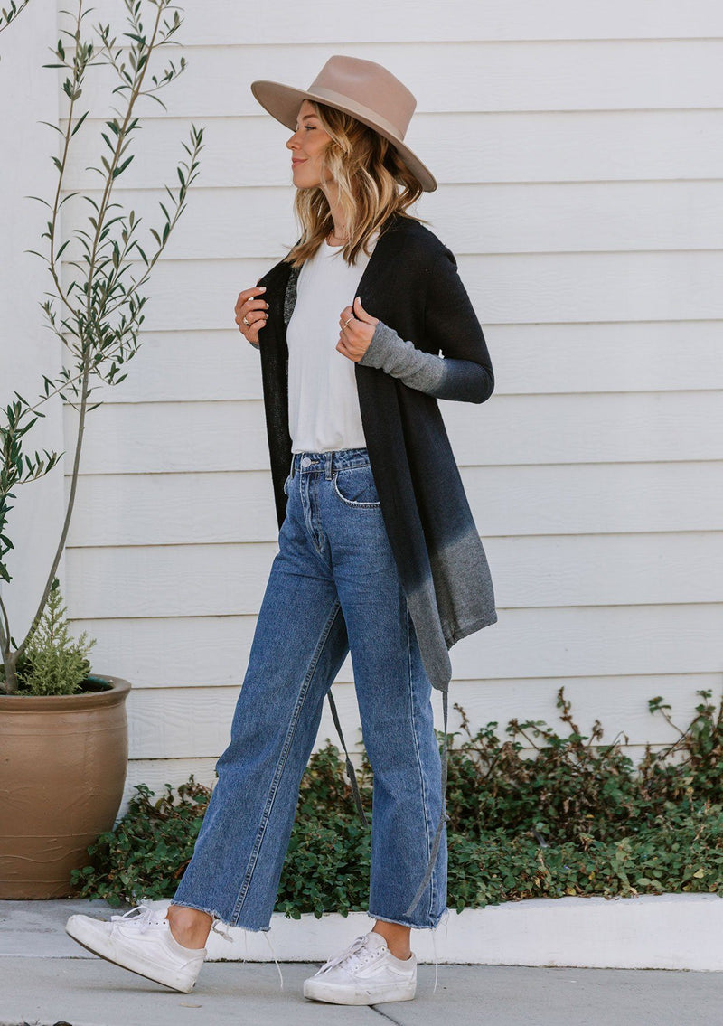 [Color: Navy/Grey] A model wearing a navy blue and grey dip dyed cardigan sweater. A lightweight bohemian cardigan with an adjustable drawstring hemline, long sleeves, and an open front. 