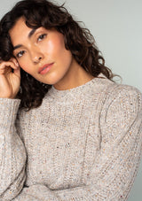 [Color: Oatmeal Multi] A close up front facing image of a brunette model wearing a perfect vintage style cream colored sweater with modern details. Voluminous long sleeves and a ladder stitch detail add a retro, yet timeless feel to this easy all season layer. Worn here with classic denim. 