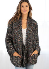 [Color: Black Multi] A fuzzy cardigan in a multi colored marled knit. Featuring voluminous long sleeves, essential side pockets, and an open front. This bohemian sweater is styled here with white denim and boots.