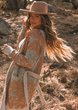 [Color: Heather Rust Bronze] A beautiful metallic jacquard wrap cardigan. Featuring a wrap front with a waist defining belted tie closure and essential side pockets. A beautiful statement sweater with light catching metallic details.