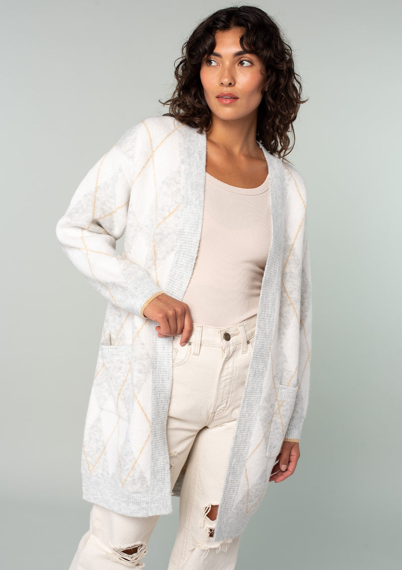 [Color: Heather Grey/Ivory] A front facing image of a brunette model wearing an ultra soft mid length cardigan in a light grey and ivory argyle plaid pattern. With long sleeves, an open front, and side pockets. 