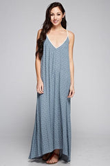 [Color: Slate Blue/Vanilla] A front facing image of a brunette woman wearing a printed light blue v neck maxi dress with a strappy back.