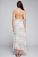 [Color: Natural Multi] A brunette model wearing a boho striped geo print halter maxi dress with a flowy shark bite skirt, open back, and a flattering v-neckline. 