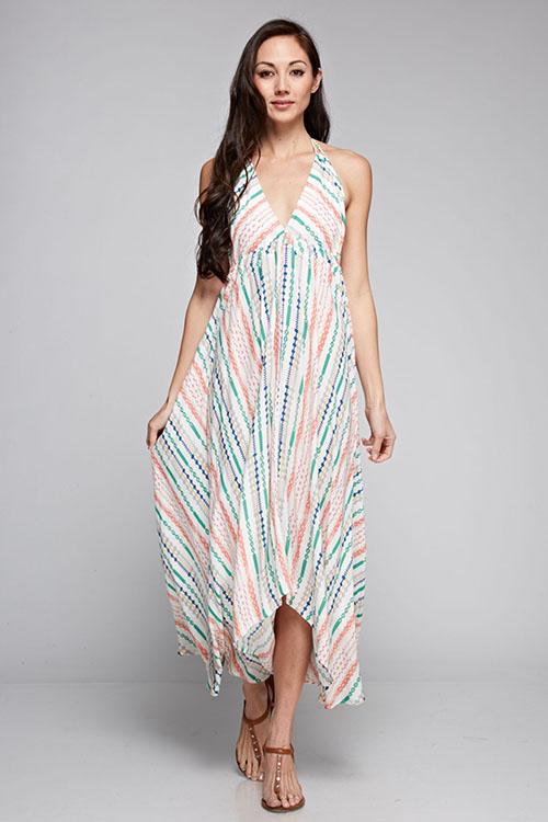 [Color: Natural Multi] A brunette model wearing a boho striped geo print halter maxi dress with a flowy shark bite skirt, open back, and a flattering v-neckline. 