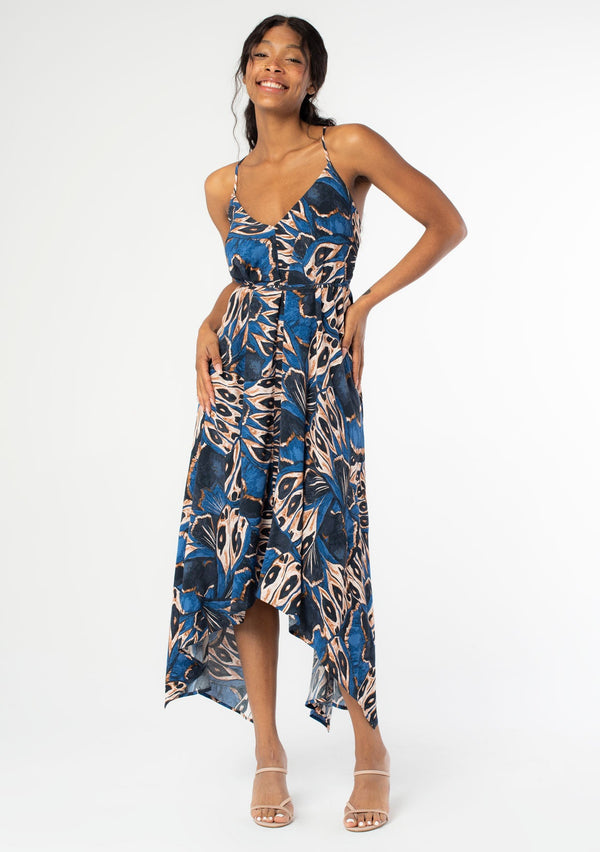 [Color: Cobalt/Tan] A front facing image of a black model wearing a blue and tan butterfly wing print mid length halter dress with long straps that can be tied multiple ways.