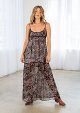 [Color: Black/Mocha] A front facing image of a blonde model wearing a brow and black printed chiffon maxi dress with a scoop neckline and spaghetti straps. 