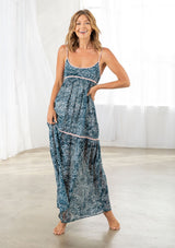 [Color: Navy/Blue] A front facing image of a blonde model wearing a blue printed chiffon maxi dress with a scoop neckline and spaghetti straps. 
