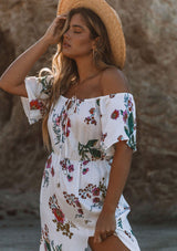 [Color: Vanilla Combo] A woman on the beach wearing an off shoulder floral print maxi dress. Featuring a front slit, short flutter sleeves, and a tie halter neck that can be tied multiple ways.