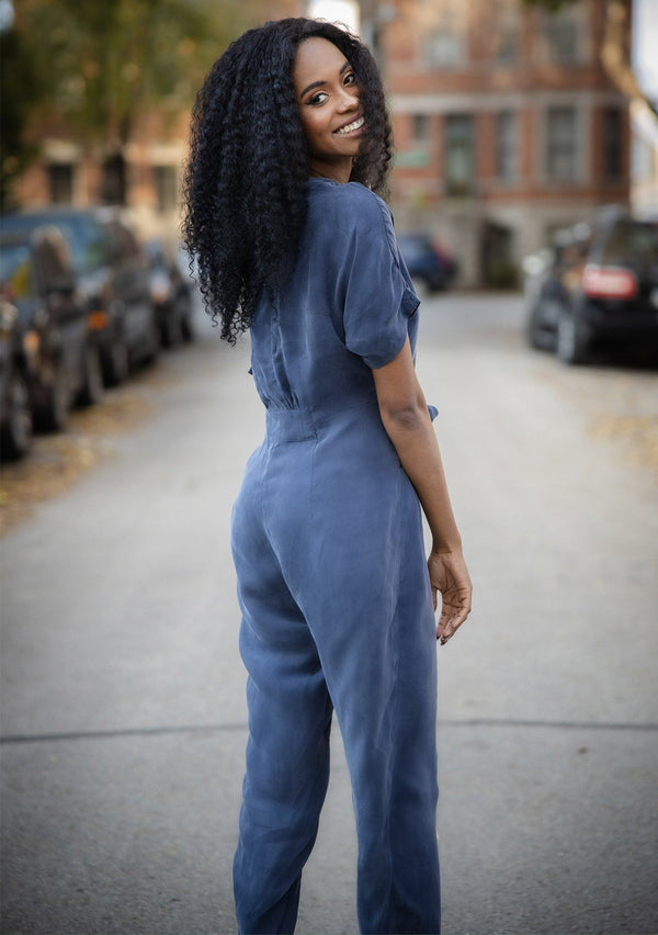 [Color: Navy] A short sleeve jumpsuit featuring a waist defining tie front detail, a flirty v back with tie detail, and an easy tapered leg.