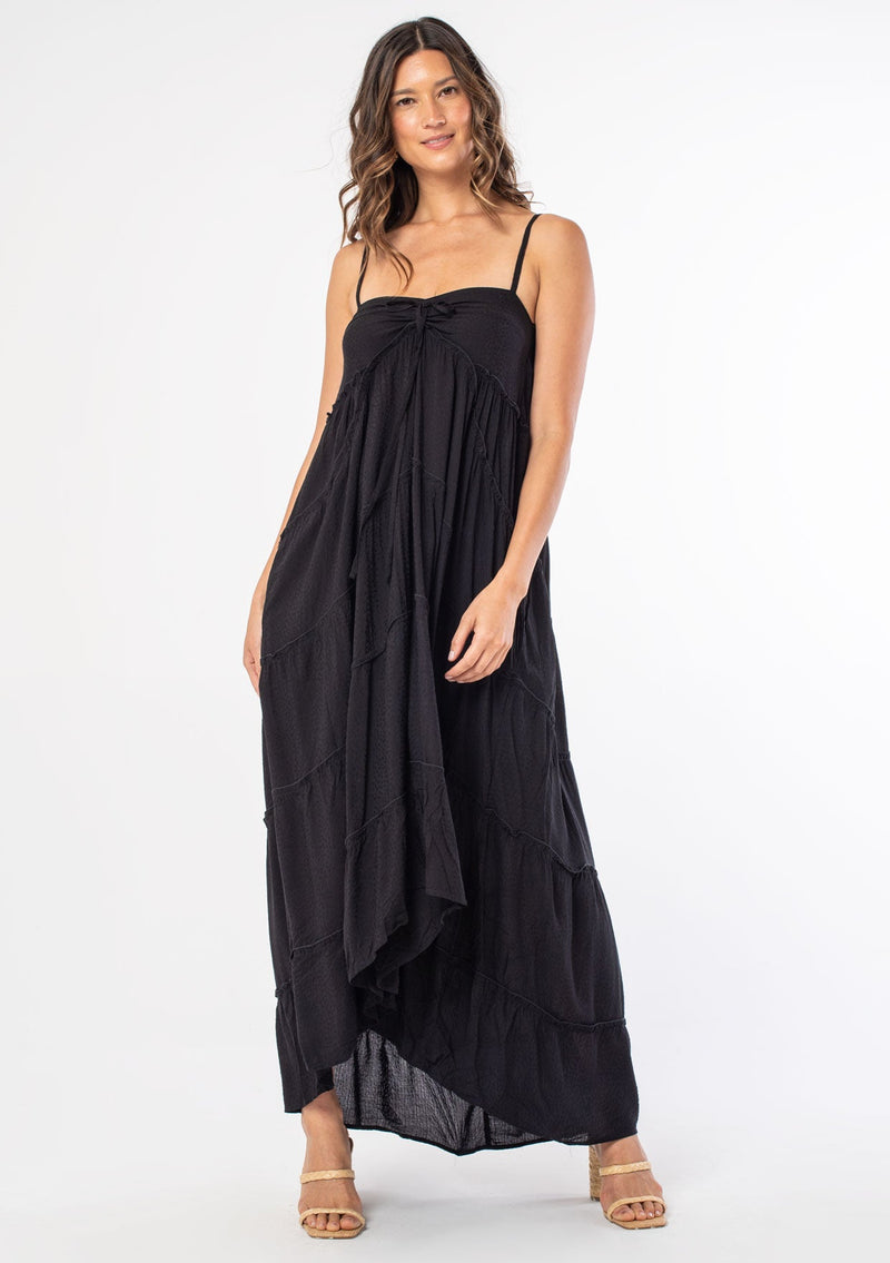 [Color: Black] A woman wearing a black bohemian tiered maxi dress.