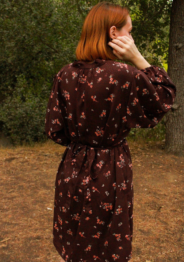 [Color: Merlot Rose] A romantic, vintage inspired floral mini dress. Featuring a v neckline, a waist defining tie back detail, and voluminous long sleeves.