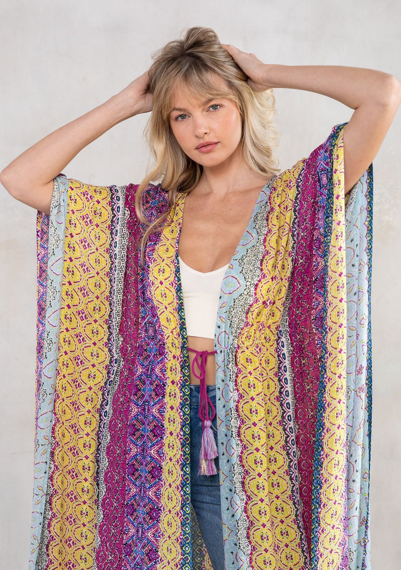 [Color: Violet Multi] A model wearing a multi colored paisley print kimono. Featuring a tassel tie closure.