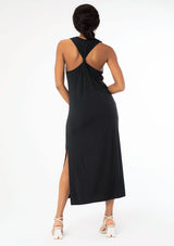 [Color: Black] A back facing image of a black model wearing a soft and stretchy sleeveless black maxi dress. With a round crew neckline, a sexy side slit, a racer back with a knot detail, and a relaxed fit.