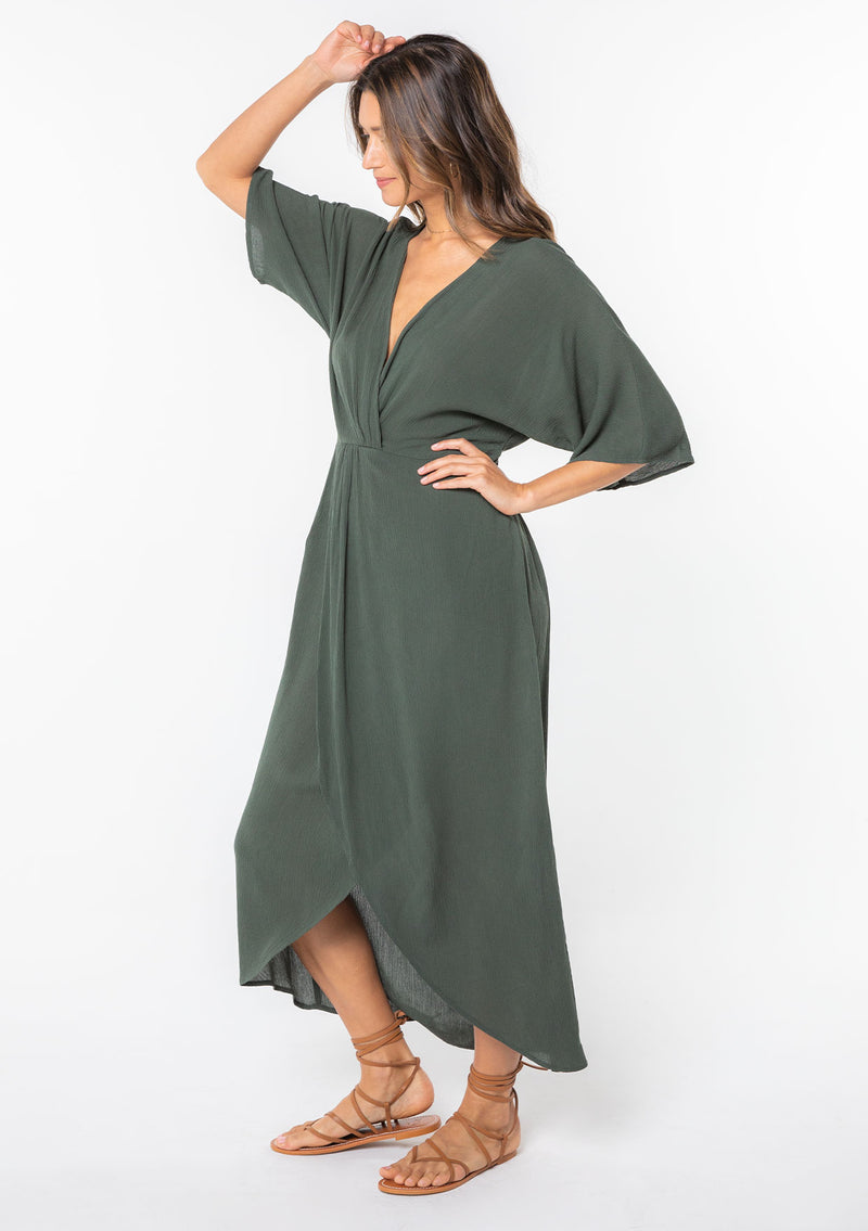 [Color: Military] A model wearing a military green maxi dress with a knot front detail and half length kimono sleeves.  