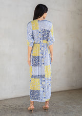 [Color: Blue/Lime] A model wearing a blue and lime green floral patchwork maxi dress with short kimono sleeves and a twist front detail. 