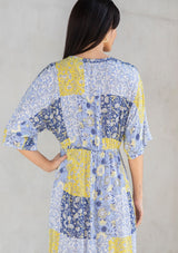[Color: Blue/Lime] A model wearing a blue and lime green floral patchwork maxi dress with short kimono sleeves and a twist front detail. 