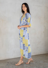 [Color: Blue/Lime] A model wearing a blue and lime green floral patchwork maxi dress with short kimono sleeves and a twist front detail. 