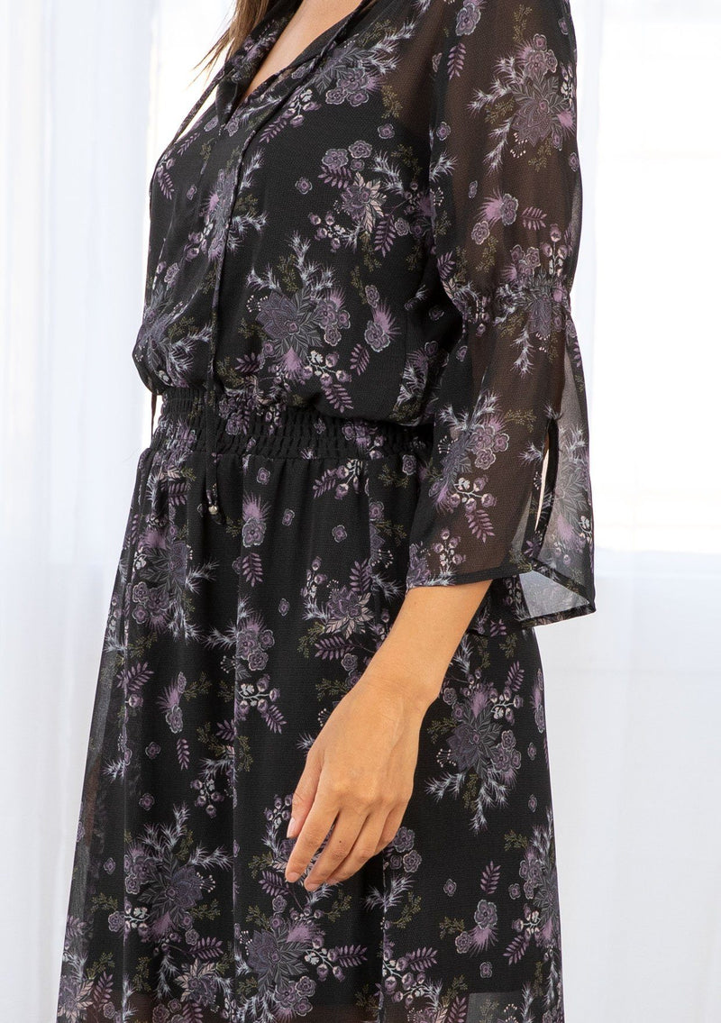 [Color: Black Stone] A bohemian maxi dress in pretty mixed florals. Featuring a split v neckline with ties, a cinched elastic waist, and long bell sleeves with a split cuff.