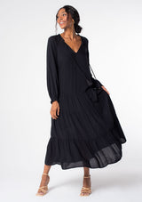 [Color: Black] A model wearing a versatile black bohemian maxi dress. Features a classic peasant dress silhouette, a relaxed fit, and delicate textured dot details throughout.