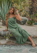 [Color: Olive] A model wearing a classic sleeveless olive green maxi dress. With a v neckline, adjustable spaghetti straps, and a tiered skirt for movement.
