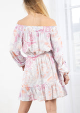[Color: Coral/Grey] A blond model wearing a tie dye mini dress. Featuring a smocked off the shoulder detail, an elastic waist, voluminous long sleeves, and a tiered ruffle trimmed skirt. 