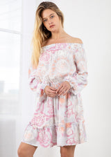 [Color: Coral/Grey] A blond model wearing a tie dye mini dress. Featuring a smocked off the shoulder detail, an elastic waist, voluminous long sleeves, and a tiered ruffle trimmed skirt. 