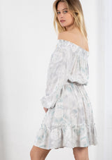 [Color: Lavender/Grey] A blond model wearing a tie dye mini dress. Featuring a smocked off the shoulder detail, an elastic waist, voluminous long sleeves, and a tiered ruffle trimmed skirt. 