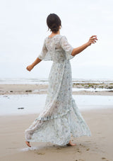 [Color: Mint/Rose] A sheer floral maxi dress with short flutter sleeves, a button front, a v neckline, and a tiered skirt.