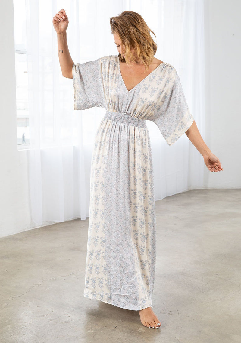 [Color: Natural/Grey] A model wearing a soft and silky mixed floral print maxi dress. With half length kimono sleeves, a smocked elastic waist, a deep v neckline, and an open back with tassel tie closure. 
