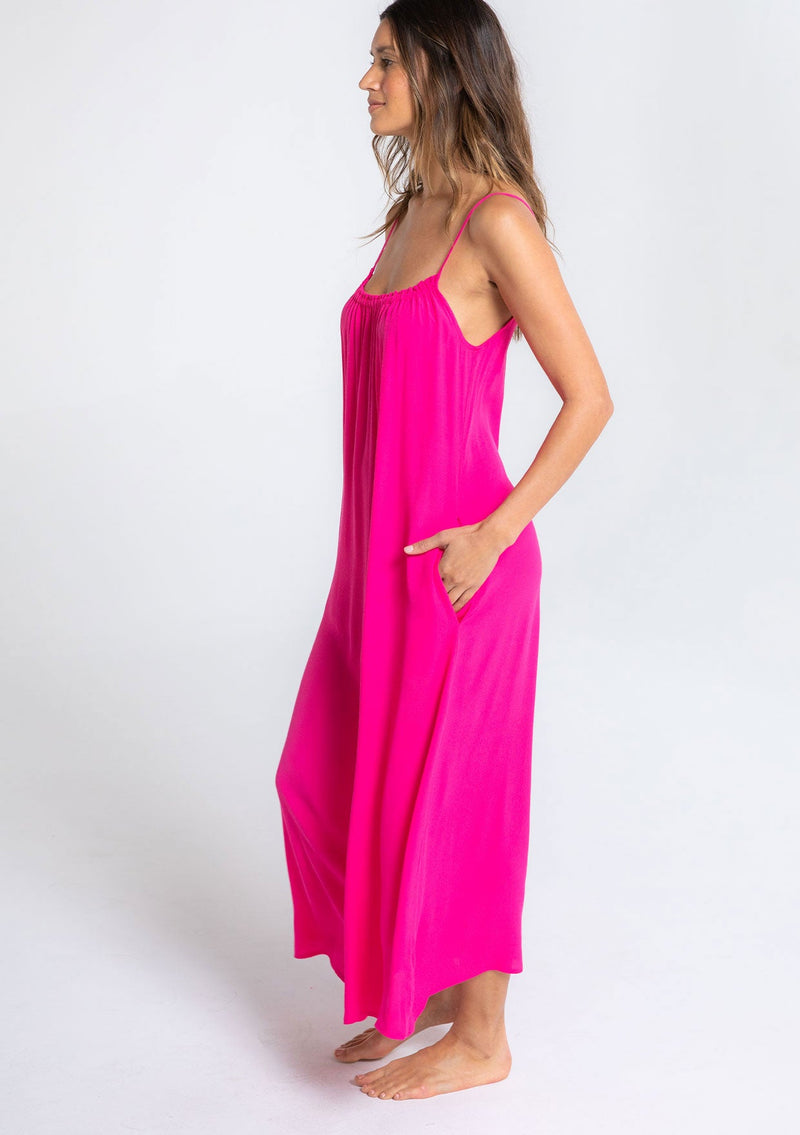 [Color: Hot Pink] A model wearing a sleeveless neon pink maxi dress. With adjustable spaghetti straps, a ruffle trimmed scooped neckline, and a v back with cutout detail.
