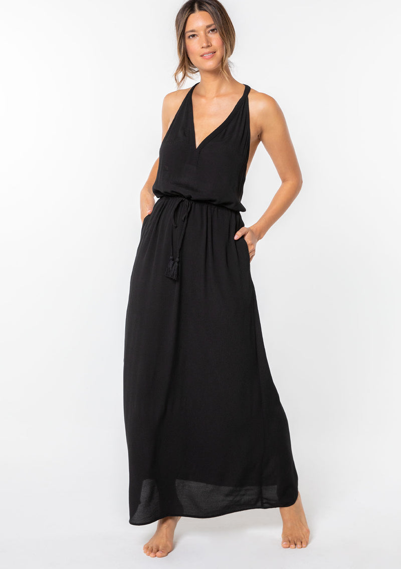 [Color: Black] A model wearing a sleeveless maxi dress. With a racerback, an adjustable drawstring waist, and v neckline.