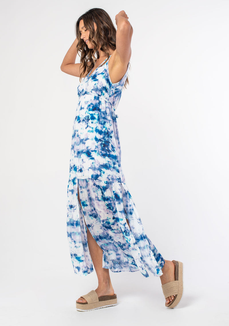 [Color: Navy/Teal] A woman wearing a flowy blue and white floral print bohemian maxi dress with wide tank top straps and a waist tie belt. 