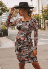 [Color: Slate/Rust] A model wearing a micro mesh mini dress in a camouflage print. With long sleeves, a round neckline, and a slim bodycon fit.