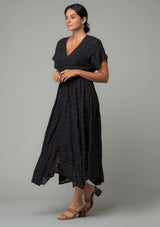[Color: Black] A front facing image of a brunette model wearing a black cotton button front maxi dress with short sleeves and an allover textured gingham.