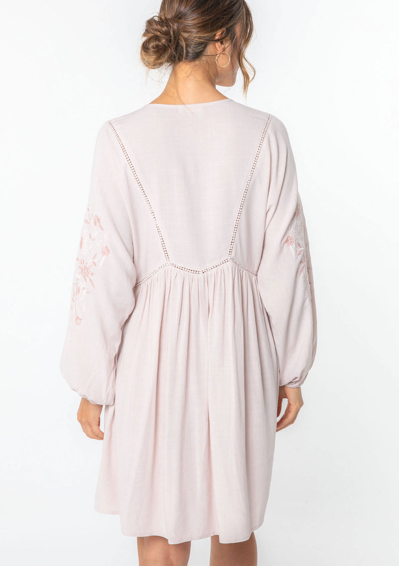 [Color: Blush/Rose] A model wearing a bohemian pink mini dress with embroidered detail.