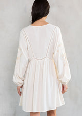 [Color: Vanilla/Sand] A model wearing a bohemian off white mini dress with embroidered detail. 