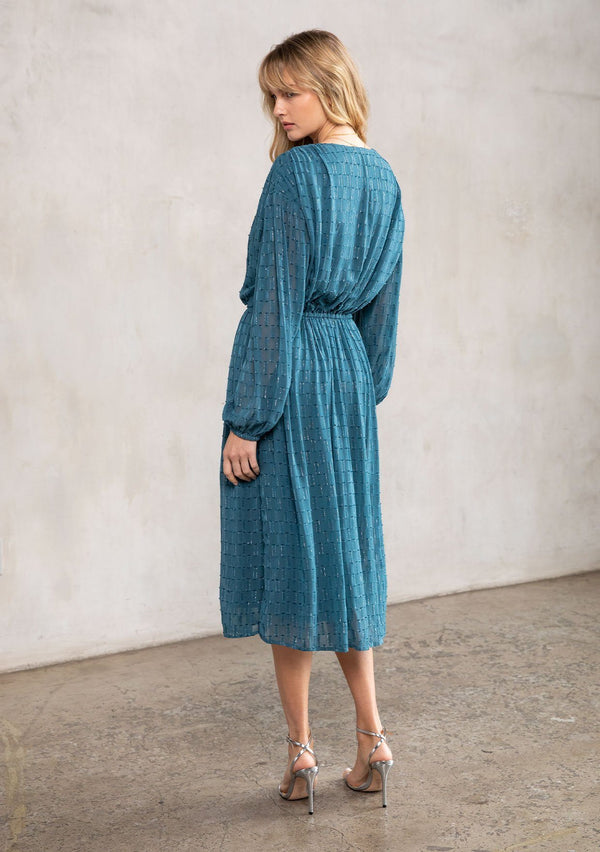 [Color: Teal] A model wearing a dreamy teal maxi dress in chiffon with metallic accents. With an adjustable drawstring waist and sheer long sleeves. A head turning holiday bohemian dress.