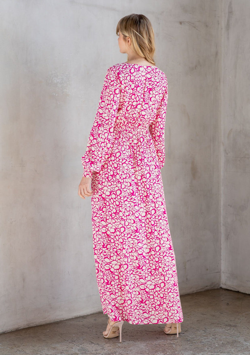 [Color: Natural/Fuchsia] A model wearing a trendy maxi dress in a natural and fuchsia pink abstract circle print. With a square neckline, voluminously long sleeves, and a leg baring side slit. 